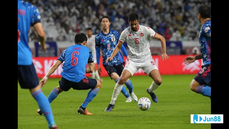 Cầu thủ Nhật Bản nỗ lực chống chọi với cầu thủ Paraguay để giành quyền kiểm soát bóng